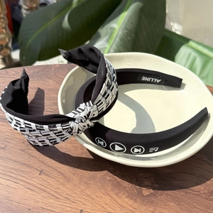 Chic piano key pattern and music icon fabric headbands set on a wooden surface