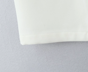 Detailed close-up of white twill weave fabric with clean stitching and premium texture