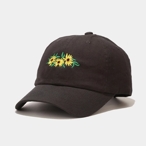Detail of sunflower embroidery on a black cotton baseball cap with ventilation holes
