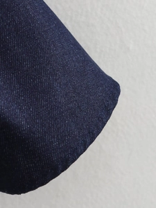 Gros plan détaillé sur la texture et les coutures du tissu denim bleu foncé d'une robe