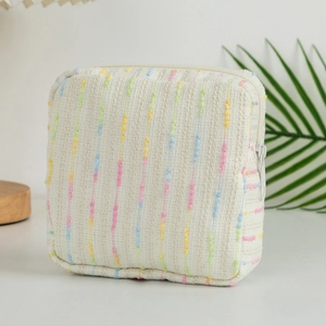Close-up of textured fabric texture and colorful dot embroidery on a makeup bag