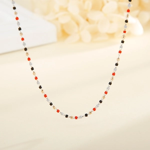 Dettaglio ravvicinato della collana a catena dorata con perle quadrate colorate