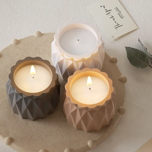 Drie lotus kandelaars met geometrische diamantpatronen in een serene omgeving