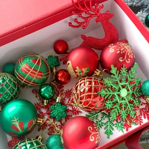 Dettaglio di palline di Natale assortite rosse, verdi e oro con renne in una scatola