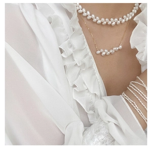 Close-up of layered pearl necklaces and multi-strand bracelets on elegant woman