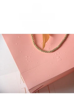 Close-up of pink gift bag with waterproof film surface and water droplets detail