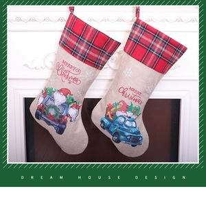 Detail of burlap Christmas stockings with red plaid cuff and Merry Christmas embroidery