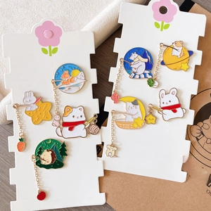 Gros plan de broches émaillées d'animaux mignons avec breloques sur cartes décoratives