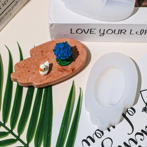 Macro shot of a palm-shaped resin coaster mold with a finished decorative tray