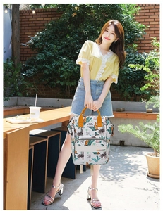 Outdoor lifestyle view of printed diaper backpack with giraffe and leaf patterns