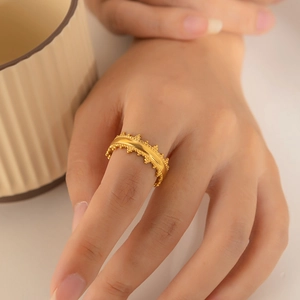 Elegant gold titanium steel gear-textured ring worn by a model in soft lighting