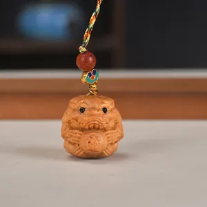 Detail-Nahaufnahme der handgeschnitzten Thuja-Holz-Zodiak-Bestie mit buntem Webband