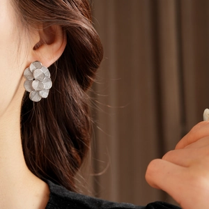 Gros plan de boucles d'oreilles en fleurs argentées portées par un mannequin