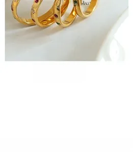 Macro shot of gold-plated vintage rings featuring red, green, and clear micro zircons