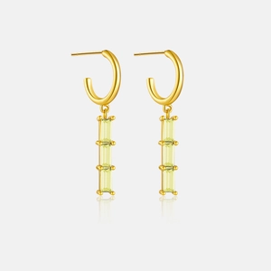 Detailed view of long 18K gold earrings with triple rectangular stones and drop design