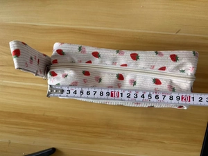 Macro shot of 20cm strawberry corduroy pencil case with measuring tape for size scale