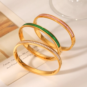 Detail of 18K gold plated stainless steel bangles set with pink, green and white zircons