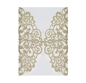Detail of laser-cut gold glitter invitation cover with intricate floral scroll patterns