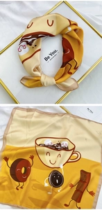 Detail of square silk scarf with cartoon dessert prints and golden frame presentation