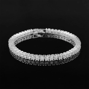 Macro shot of silver Y2K tennis bracelet with white zircon stones on black background
