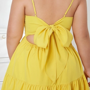 Detail of yellow backless dress featuring a bow tie design and delicate spaghetti straps