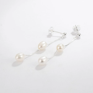 Detail of silver S925 drop earrings with long tassel chains and natural freshwater pearls