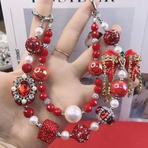 Close-up of handmade red beaded phone chain with rhinestone ball and bow tassel