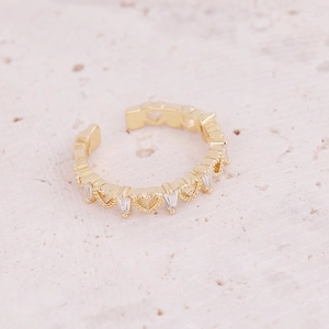 Macro detail of gold adjustable ring with inlaid white zircons and hollow heart design