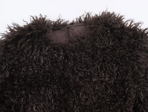 Close-up of the round neckline and dark brown curly faux fur texture on the jacket