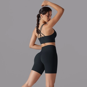 Dettaglio del reggiseno sportivo incrociato e pantaloncini fitness a vita alta neri