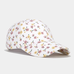 Détail de l'imprimé floral rose et texture de la toile sur une casquette blanche