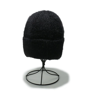 Close-up of black ribbed knit beanie showing thick texture and folded cuff detail
