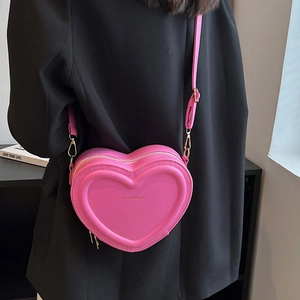 Elegante borsa a tracolla rosa a forma di cuore in pelle PU indossata da una modella