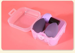 Close-up of purple makeup sponge set with handle and drop shapes in clear plastic box