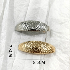 Detail of hammered metal hair clips in gold and silver showing 8.5cm length measurement