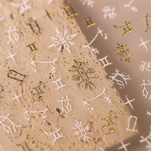 Goldene und weiße Nagelaufkleber mit Astrologie-Sternen und Sternbild-Designs