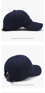 Detail of navy blue cotton baseball cap featuring white embroidery and adjustable metal buckle
