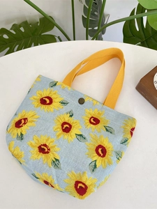 Light blue sunflower canvas tote bag with yellow handles on a minimalist table