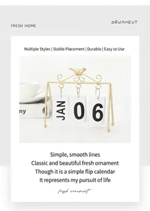 Detail of creative gold bird metal flip calendar with PVC cards for home table decor