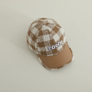 Close-up of checkered wool fabric and leather brim with TOON! embroidery on baby cap