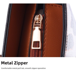 Detail of smooth gold-tone zipper on Saffiano leather tote with precise stitching