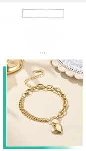 Detailed close-up of 18K gold-plated double-chain bracelet with solid heart pendant