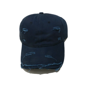 Close-up of distressed details and frayed edges on navy blue vintage baseball cap