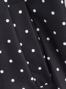 Vue macro du tissu à pois noir et blanc montrant la texture lisse et le drapé fluide
