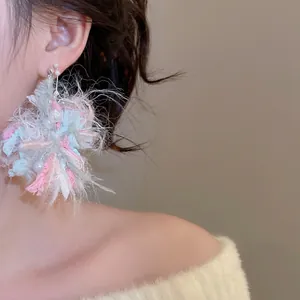 Sweet floral yarn pendant earrings with pearls on model, soft pastel wool texture