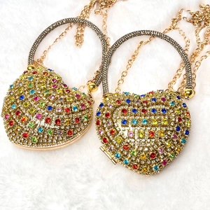 Close-up of luxury heart evening bags with colorful rhinestones on white faux fur