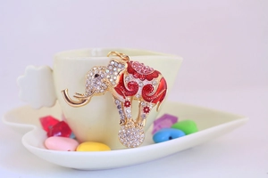 Detail of a gold-plated flying elephant keychain adorned with sparkling rhinestones