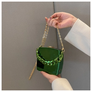 Detail of green glossy hardshell evening bag with metallic and thick link chains