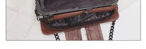 Macro view of brown vintage bag interior with multi-compartments and metal chain strap