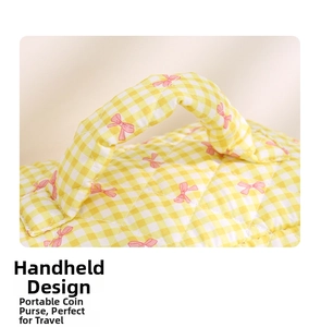 Detail of quilted handle on a yellow plaid cosmetic bag with pink bow pattern